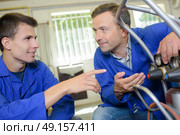 Trainee pointing to gauge on canister. Стоковое фото, агентство Ingram Publishing / Фотобанк Лори