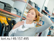 Lady in clothes shop, wearing scarf, holding her hair up. Стоковое фото, агентство Ingram Publishing / Фотобанк Лори