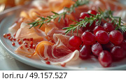 Enjoy a platter of Italian Prosciutto Ham garnished with grapes and fresh herbs for a flavorful culinary experience. Стоковое AI-изображение, AI-художник Anastasy Yarmolovich / Фотобанк Лори