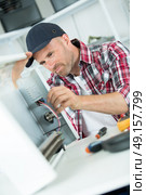 smily repairman fixing computer unit. Стоковое фото, агентство Ingram Publishing / Фотобанк Лори