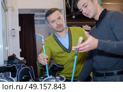 happy woman with man selecting golf club in store. Стоковое фото, агентство Ingram Publishing / Фотобанк Лори