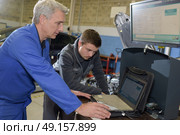 auto mechanic teacher and trainee performing tests at mechanic school. Стоковое фото, агентство Ingram Publishing / Фотобанк Лори