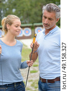Archers looking at bows. Стоковое фото, агентство Ingram Publishing / Фотобанк Лори