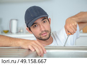 Man fitting kitchen sink. Стоковое фото, агентство Ingram Publishing / Фотобанк Лори