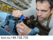 locksmith cutting new key. Стоковое фото, агентство Ingram Publishing / Фотобанк Лори