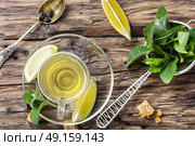 Tea with mint and lemon. tea brewed with lime and mint on wooden background. Стоковое фото, агентство Ingram Publishing / Фотобанк Лори