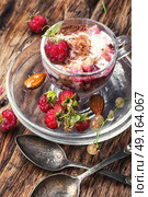 vanilla ice cream with raspberry. Raspberry ice cream with currants in glass cup.Sundae on vintage rustic background. Стоковое фото, агентство Ingram Publishing / Фотобанк Лори