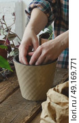Vertical video. Woman replanting houseplant adding expanded clay into new pot. Стоковое видео, видеограф Маргарита Кирьякова / Фотобанк Лори