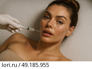 Бьюти-инъекции: Увеличение губ гиалуроновой кислотой для молодой женщины в косметическом салоне. Стоковое AI-изображение, AI-художник Оксана Хорватич / Фотобанк Лори