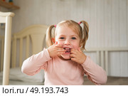 Little Girl joking sticking tongue out with silly expression. Child making face. Funny foolishness portrait of baby girl laughing in bedroom. Adorable Caucasian kid doing crazy comical gesture at home. Стоковое фото, фотограф Марина Демидюк / Фотобанк Лори