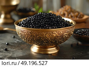 Decorative bowl filled with black caviar on a rustic tabletop in a warm-lit setting. Стоковое AI-изображение, AI-художник Климов Денис / Фотобанк Лори