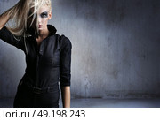 Attractive, blond and beautiful woman posing over the grungy wall. Стоковое фото, агентство Ingram Publishing / Фотобанк Лори