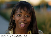 A humorous moment captured as a woman sticks out her tongue in a comical expression. Стоковое AI-изображение, AI-художник Данила Большаков / Фотобанк Лори