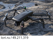 A black and gray remote-controlled flying device in action. Стоковое AI-изображение, AI-художник Данила Большаков / Фотобанк Лори