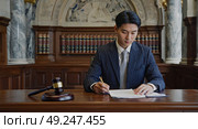 A court employee reviews the case in the courtroom. The lawyer is in charge of the client's defense process. Review of the court case. Стоковое AI-изображение, AI-художник Антон Слабоспицкий / Фотобанк Лори