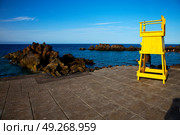 yellow lifeguard chair cabin  in lanzarote  spain   rock stone sky cloud beach  water  musk pond  coastline and summer . Стоковое фото, агентство Ingram Publishing / Фотобанк Лори
