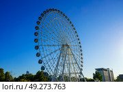 Tashkent, Uzbekistan - August 12, 2023: High ferris wheel at sunset or sunrise with blue sky in an amusement park Navruz or Anhor. Редакционное фото, фотограф Емельянов Евгений Викторович / Фотобанк Лори