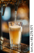 Pouring a Refreshing Beverage Into a Clear Glass at a Lively Bar During the Evening Hours. Стоковое AI-изображение, AI-художник Юлия Гапеенко / Фотобанк Лори