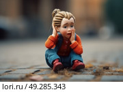 A small doll is seated on the ground, positioned in a stationary manner. Стоковое AI-изображение, AI-художник Данила Большаков / Фотобанк Лори