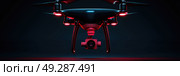 A drone with red navigation lights hovers in darkness, showcasing its camera and sleek design. Стоковое AI-изображение, AI-художник Данила Большаков / Фотобанк Лори