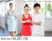 Adolescent dance duo, boy and girl, refining slow foxtrot with female coach. Стоковое фото, фотограф Яков Филимонов / Фотобанк Лори