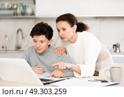 Mother helps her teenage son do schoolwork, solve problems together and find answers. Стоковое фото, фотограф Яков Филимонов / Фотобанк Лори