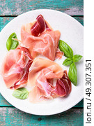 Sliced of Spanish jamon. Sliced of Traditional Spanish jamon on a wooden retro background. Стоковое фото, агентство Ingram Publishing / Фотобанк Лори