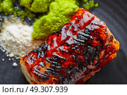 Grilled smoked eel with green apple and citrus on black plate. Стоковое фото, агентство Ingram Publishing / Фотобанк Лори