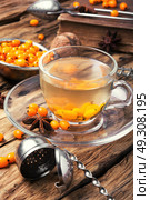 tea with sea-buckthorn. cup with healing tea with berries of sea-buckthorn on wooden retro background. Стоковое фото, агентство Ingram Publishing / Фотобанк Лори