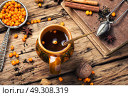 healthy tea with sea-buckthorn. teacup with healing berry tea with sea-buckthorn on retro background. Стоковое фото, агентство Ingram Publishing / Фотобанк Лори