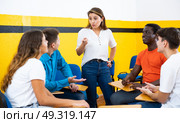 Female student discussing with groupmates sitting in circle in auditorium during classes. Стоковое фото, фотограф Яков Филимонов / Фотобанк Лори