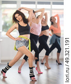 Female instructor performing graceful sass dance movements during group class. Стоковое фото, фотограф Яков Филимонов / Фотобанк Лори