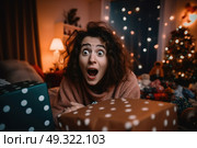 A woman with a startled facial expression lies on the floor, showing surprise and shock. Стоковое AI-изображение, AI-художник Данила Большаков / Фотобанк Лори