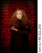 Scary witch at brick wall background. Стоковое фото, агентство Ingram Publishing / Фотобанк Лори