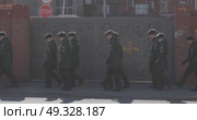 Russia, St.Petersburg, 26 March 2025: a column of cadets of military forces walk along the fence and gates with the symbols of the armed forces. Редакционное видео, видеограф Vladimir Drozdin / Фотобанк Лори