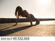 Fitness woman doing exercices on summer sunset. Стоковое фото, агентство Ingram Publishing / Фотобанк Лори
