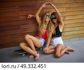 Best friends teen girls on skate heart shape hands fingers smiling having fun. Стоковое фото, агентство Ingram Publishing / Фотобанк Лори