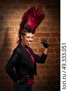 Young punk girl on brick wall background. Стоковое фото, агентство Ingram Publishing / Фотобанк Лори