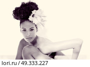 Portrait of a young black woman, model of fashion, with big flowers in her hair . Стоковое фото, агентство Ingram Publishing / Фотобанк Лори