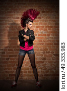 Young punk girl on brick wall background. Стоковое фото, агентство Ingram Publishing / Фотобанк Лори