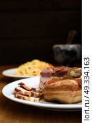smoked pork ribs on white plate on wooden background. Стоковое фото, агентство Ingram Publishing / Фотобанк Лори