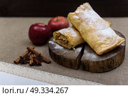 Apple strudel on wooden end of a tree with apples, cinnamon and star anise. Стоковое фото, агентство Ingram Publishing / Фотобанк Лори