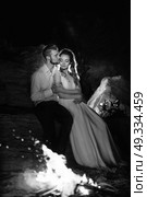 young couple the bride and groom warm around the fire at night. Стоковое фото, агентство Ingram Publishing / Фотобанк Лори
