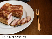 smoked pork ribs on white plate on wooden background. Стоковое фото, агентство Ingram Publishing / Фотобанк Лори