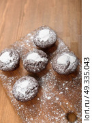 chocolate muffins with white icing lying on a Board sprinkled with powdered sugar. Стоковое фото, агентство Ingram Publishing / Фотобанк Лори