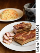 smoked pork ribs on white plate on wooden background. Стоковое фото, агентство Ingram Publishing / Фотобанк Лори