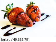 strawberries with a tail drenched in liquid chocolate on white background. Стоковое фото, агентство Ingram Publishing / Фотобанк Лори
