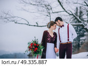 groom in a brown and bride in burgundy in the mountains Carpathians. Стоковое фото, агентство Ingram Publishing / Фотобанк Лори