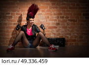 Young punk girl on brick wall background. Стоковое фото, агентство Ingram Publishing / Фотобанк Лори