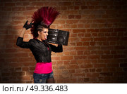 Young punk girl on brick wall background. Стоковое фото, агентство Ingram Publishing / Фотобанк Лори